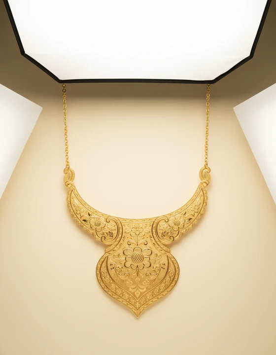 Macro of the engraved centrepiece of a 22K gold bridal necklace.