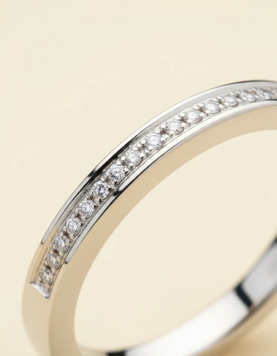 Macro of a white gold band set with a diagonal row of pave diamonds.